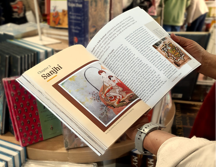 A lady looking at the Sanjhi chapter of the book