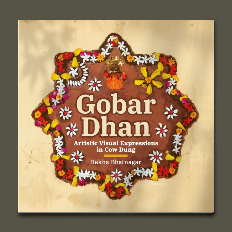 A star shape made up of cow dung decorated with bright flowers, with the book title in the centre
