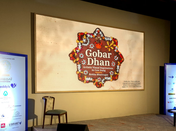 Colourful star shaped Sanjhi design with the book title in it, shown on a large LCD screen