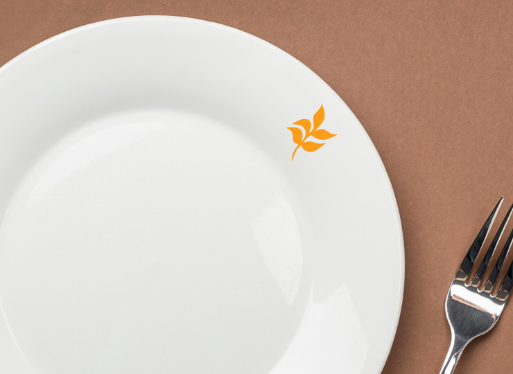 A small orange leaf printed on a white plate