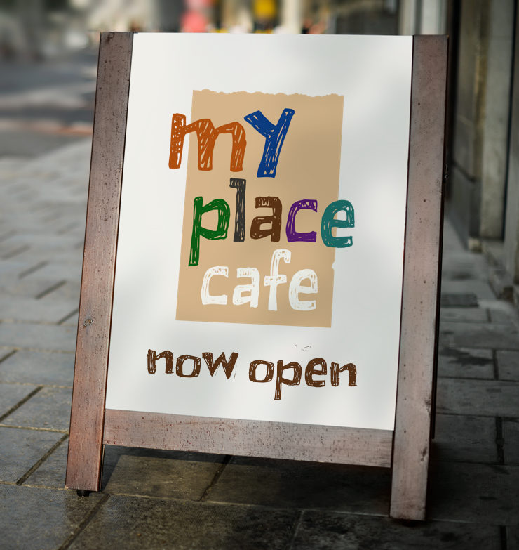 My Place Cafe logo printed on a standing poster placed on a pavement