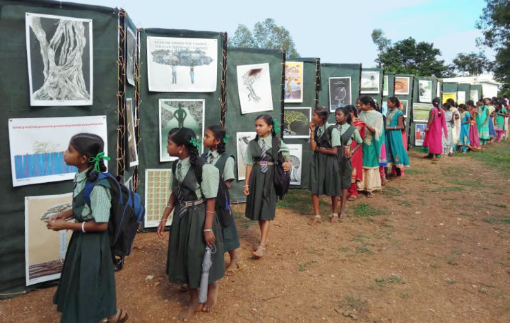 Local school and college girl students looking at posters displayed outdoors