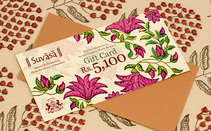 A gift card and an envelope, over a hand-block printed fabric background