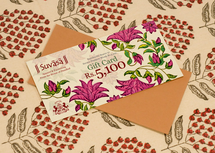 A gift card and a brown colour envelope placed on a block printed fabric