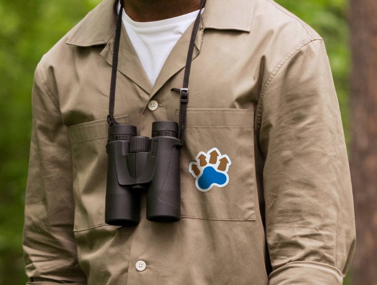 The logo, with a white casing around it, on the pocket of a nature guide's shirt