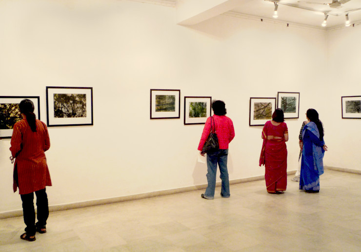 Visitors looking at framed photographs displayed in an art gallery