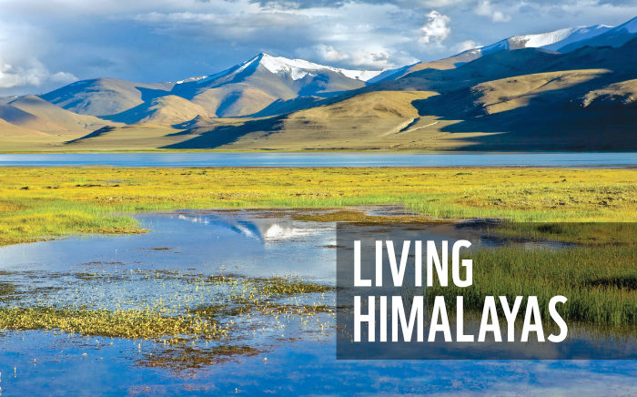 Photograph of a lake with mountains and clouds in the background, and the text ‘Living Himalayas’